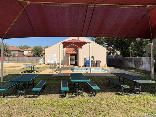 a view of a patio with a table and chairs under an umbrella
