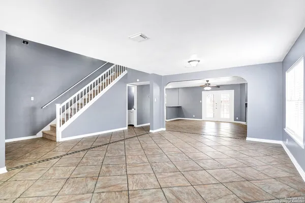a view of an empty room with window and stairs