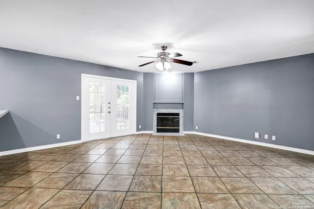 a view of an empty room with a fireplace and a window