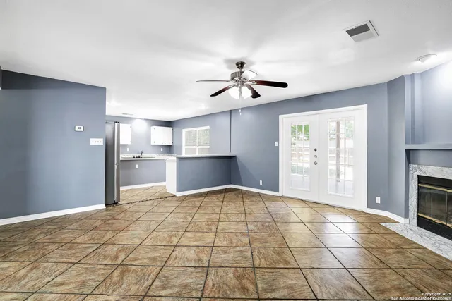 a kitchen with stainless steel appliances a sink a stove a refrigerator cabinets and a window