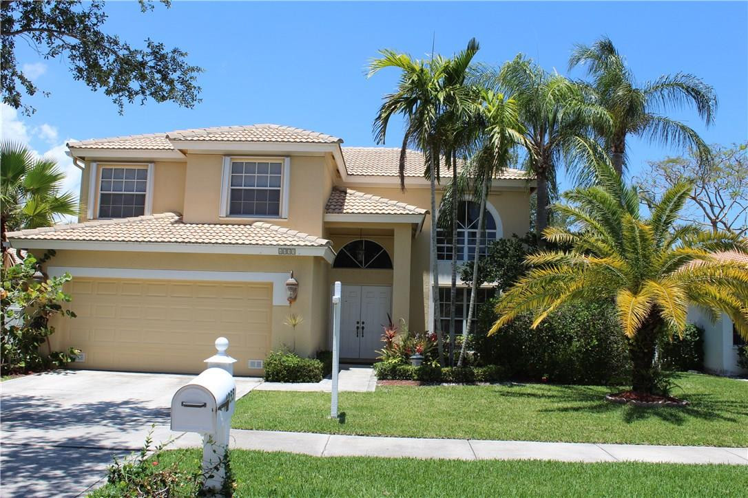4055 Sabal Lakes Road Delray Beach, FL 33445 - Photo 1 of 13 a front view of a house with a garden