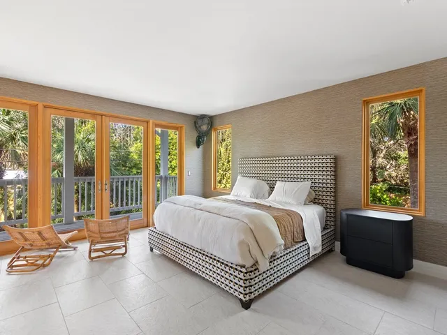 a spacious bedroom with a bed and a couch next to a window