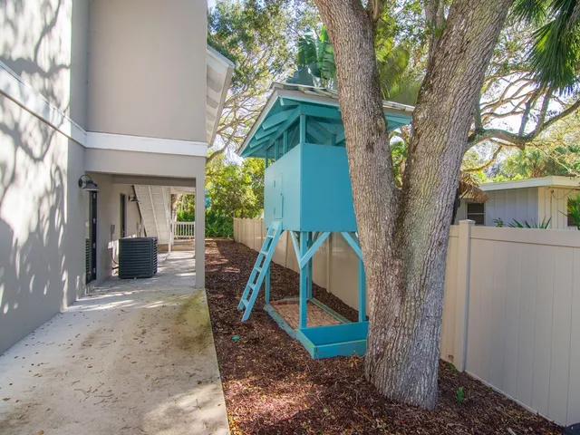 a view of a house with backyard and a tree