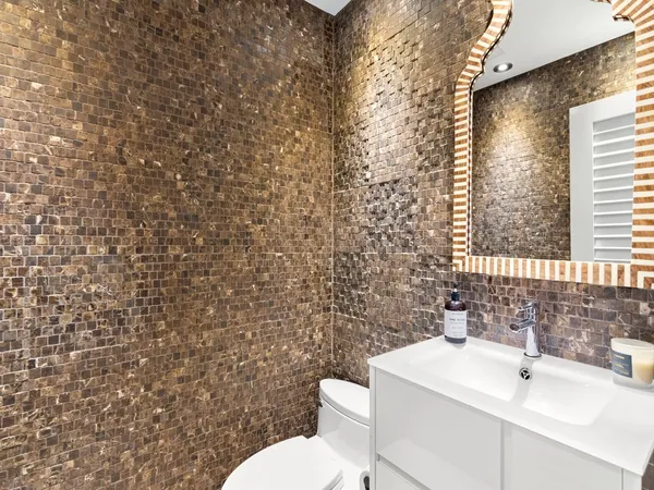 a bathroom with a sink a toilet and mirror