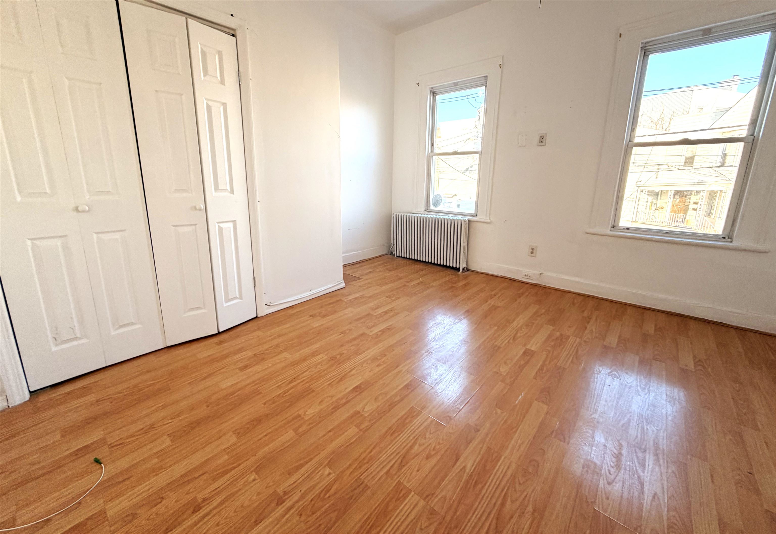 1011 Paterson Plank Road, Unit 2 North Bergen, NJ 07047 - Photo 12 of 12 an empty room with wooden floor and windows
