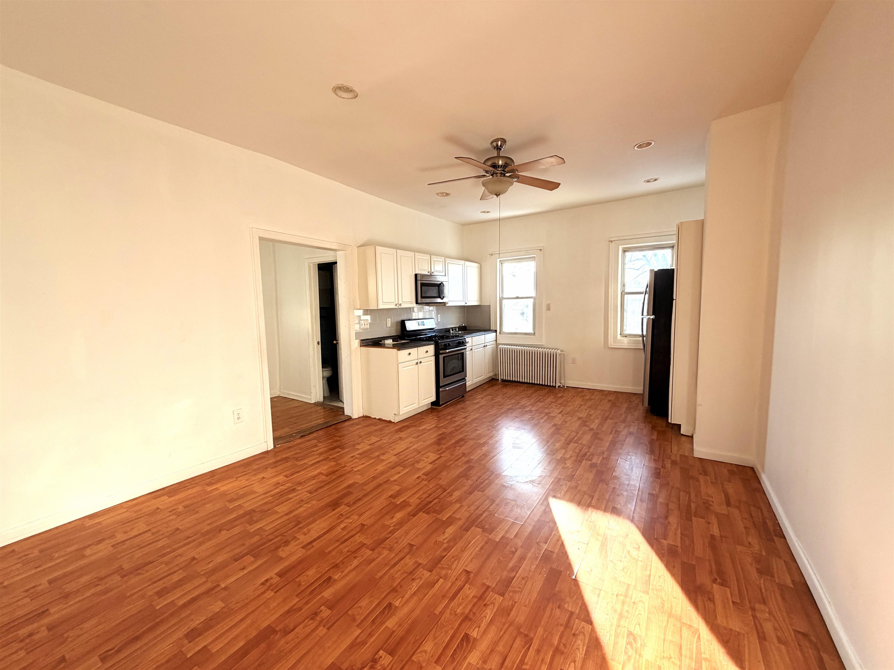 1011 Paterson Plank Road, Unit 2 North Bergen, NJ 07047 - Photo 6 of 12 a view of a kitchen with wooden floor and a kitchen space