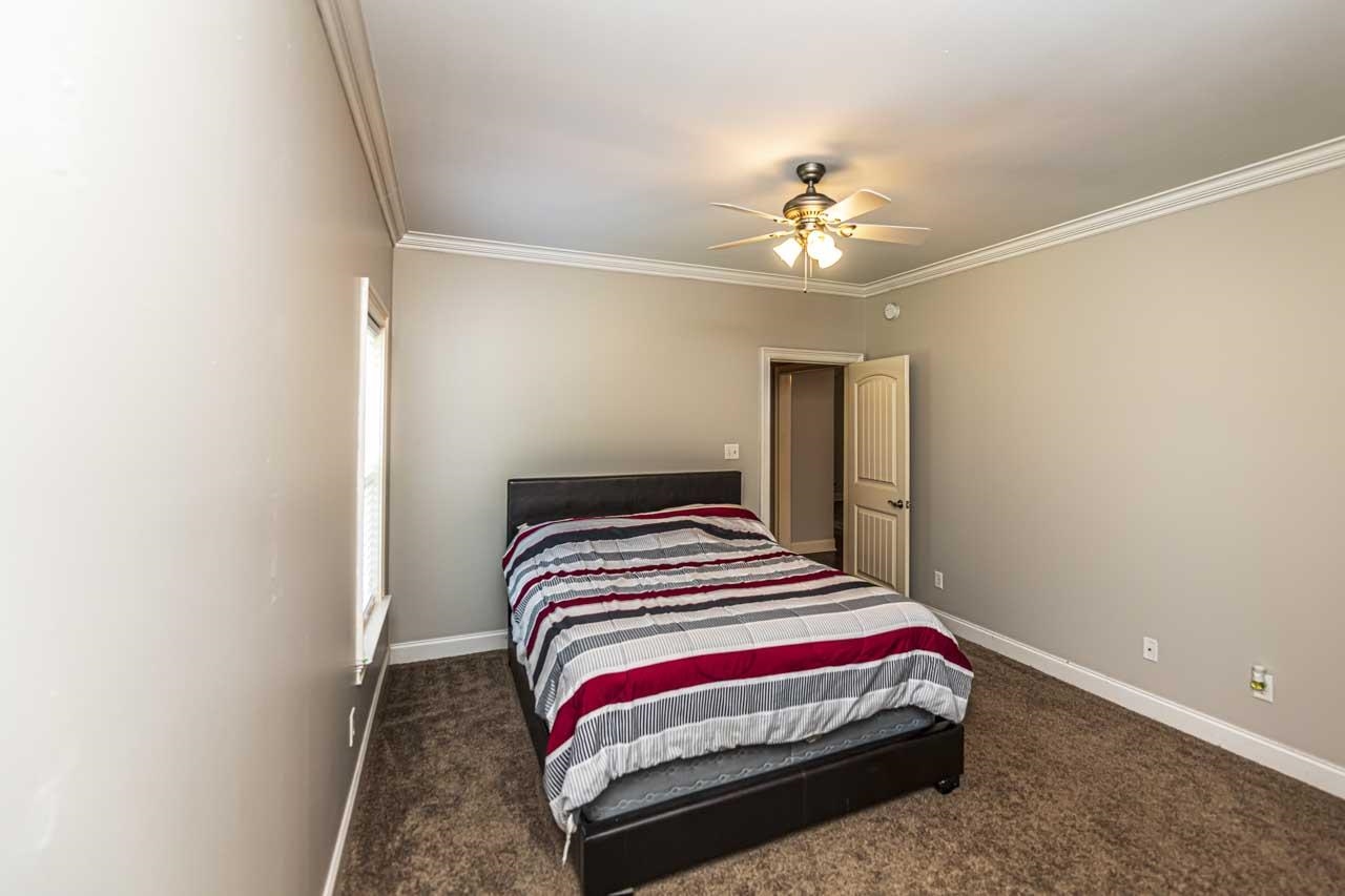 516 Egypt Road Munford, TN 38058 - Photo 24 of 40 a bedroom with a bed and a chandelier