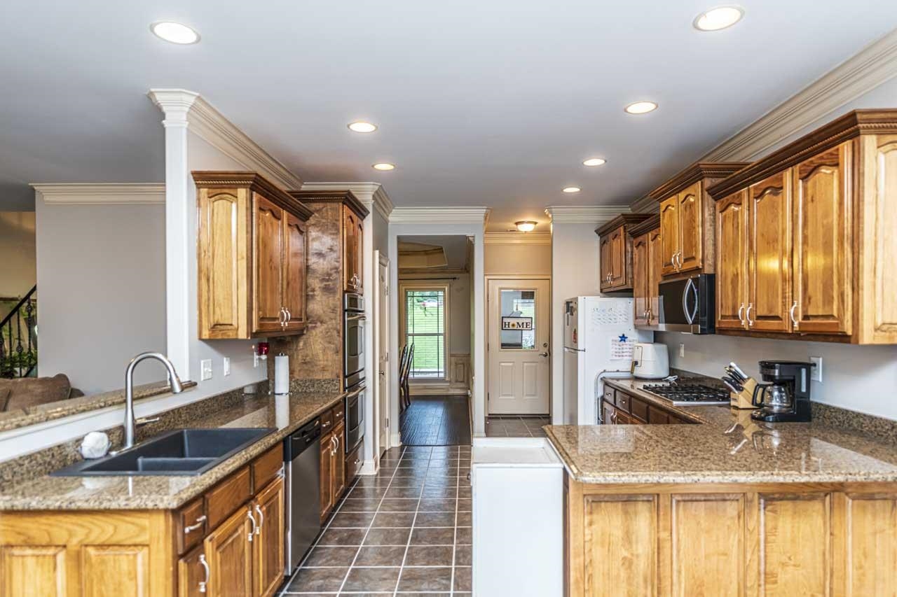 516 Egypt Road Munford, TN 38058 - Photo 30 of 40 a kitchen with stainless steel appliances granite countertop a sink stove and refrigerator