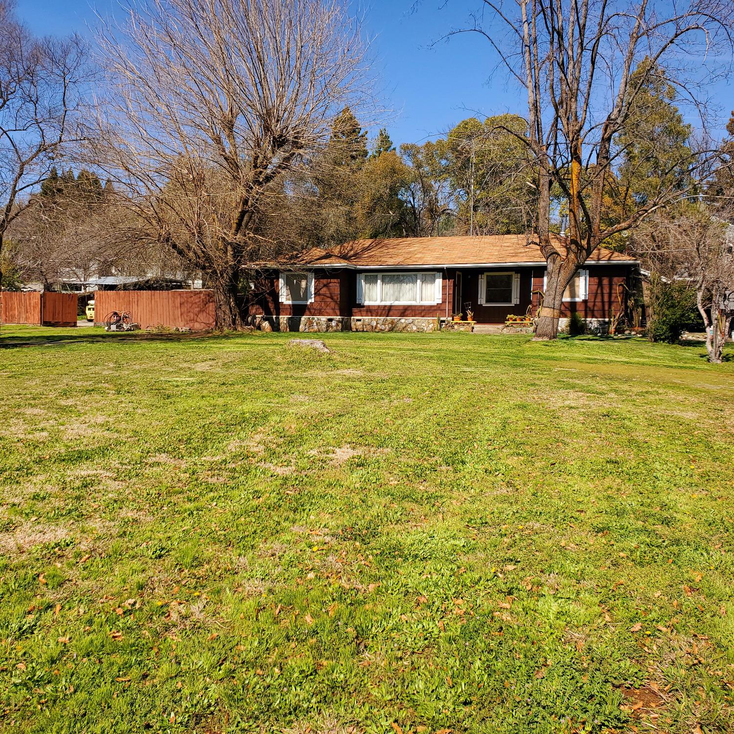 a view of a big house with a big yard and large trees