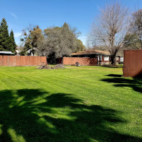 a backyard of a house with lots of green space and fountain