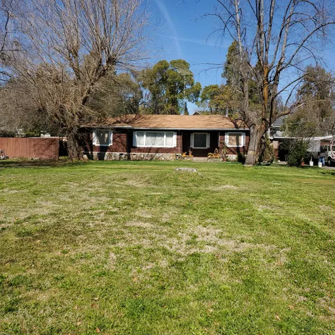 a yellow house sitting in middle of the middle of a field