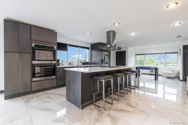 a kitchen with stainless steel appliances granite countertop a stove a sink a oven and a dining table