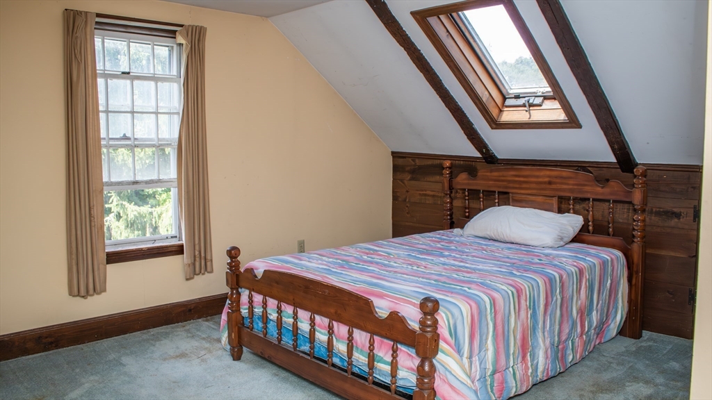 562 North Avenue Rochester, MA 02770 - Photo 21 of 32 a bedroom with a bed a dresser and a window