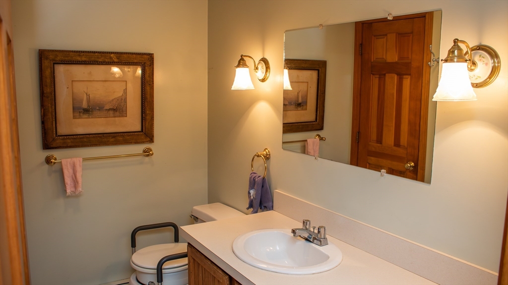 562 North Avenue Rochester, MA 02770 - Photo 25 of 32 a bathroom with a sink a mirror and a toilet