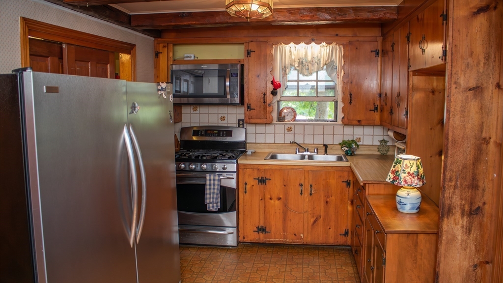 562 North Avenue Rochester, MA 02770 - Photo 9 of 32 a kitchen with stainless steel appliances granite countertop a refrigerator a stove a sink and dishwasher with wooden floor