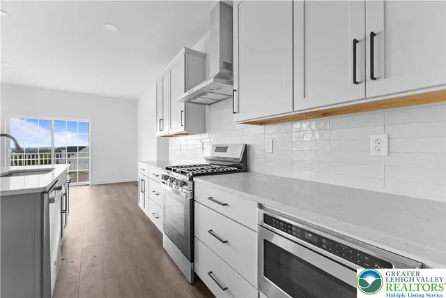 a kitchen with granite countertop white cabinets and white appliances