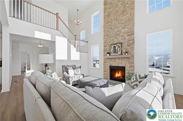 a living room with furniture a fireplace and a large mirror