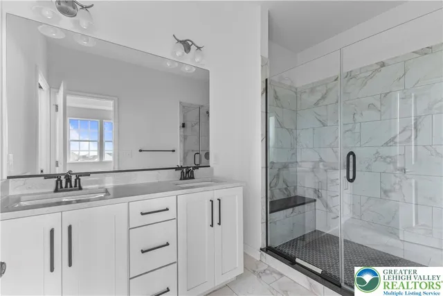 a bathroom with a granite countertop sink a mirror and shower