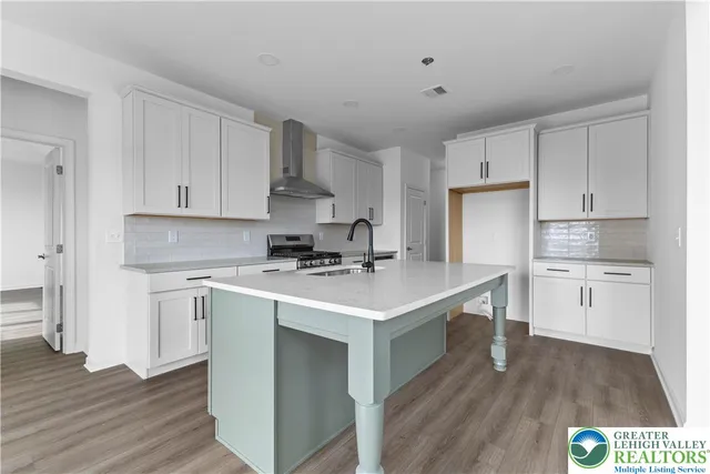 a kitchen with a sink a stove a refrigerator and white cabinets