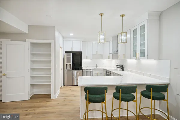 a kitchen with kitchen island a stove a table and chairs in it