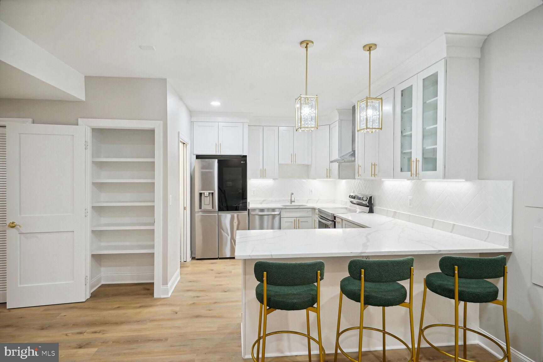 a kitchen with kitchen island a stove a table and chairs in it