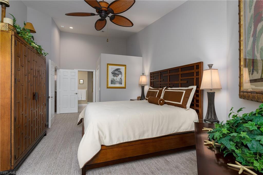 195 Vintage Circle, Unit E205 Naples, FL 34119 - Photo 16 of 34 a bedroom with a bed chandelier and a window