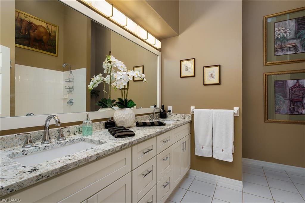 195 Vintage Circle, Unit E205 Naples, FL 34119 - Photo 20 of 34 a bathroom with a double vanity sink and a mirror