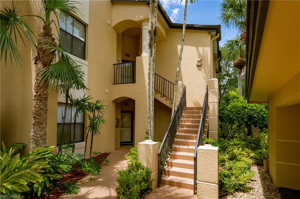 195 Vintage Circle, Unit E205 Naples, FL 34119 - Photo 2 of 34 a front view of a house with a garden