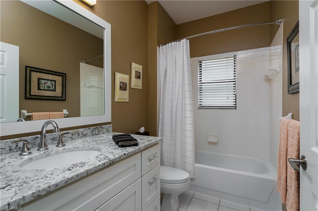195 Vintage Circle, Unit E205 Naples, FL 34119 - Photo 24 of 34 a bathroom with a granite countertop sink toilet and shower