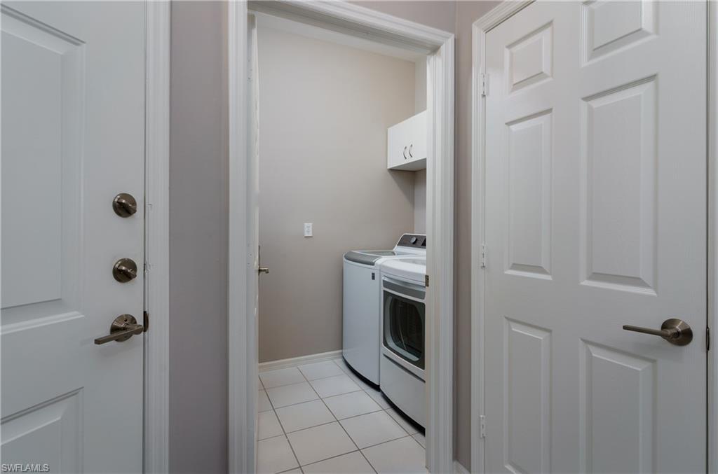 195 Vintage Circle, Unit E205 Naples, FL 34119 - Photo 25 of 34 a utility room with cabinets washer and dryer