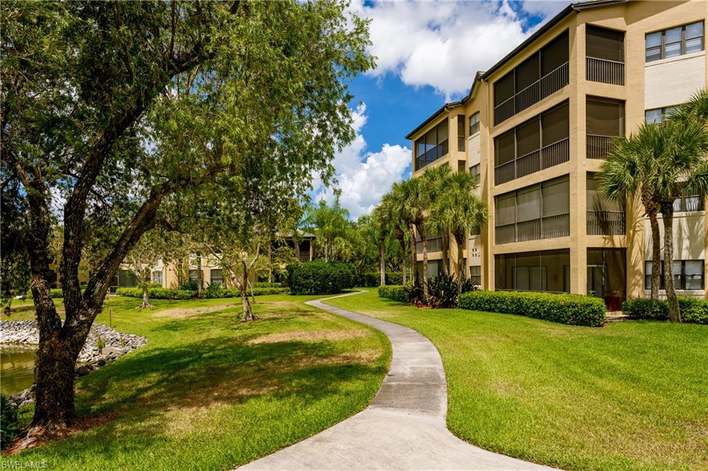195 Vintage Circle, Unit E205 Naples, FL 34119 - Photo 5 of 34 a view of a building with a yard