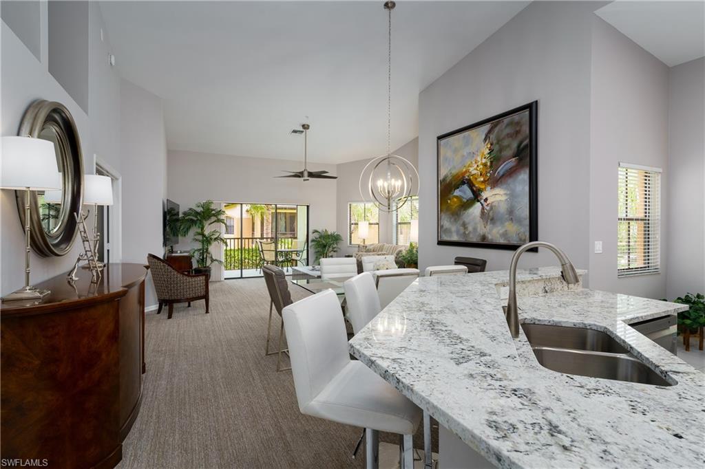 195 Vintage Circle, Unit E205 Naples, FL 34119 - Photo 6 of 34 a view of a dining room with furniture a livingroom and chandelier