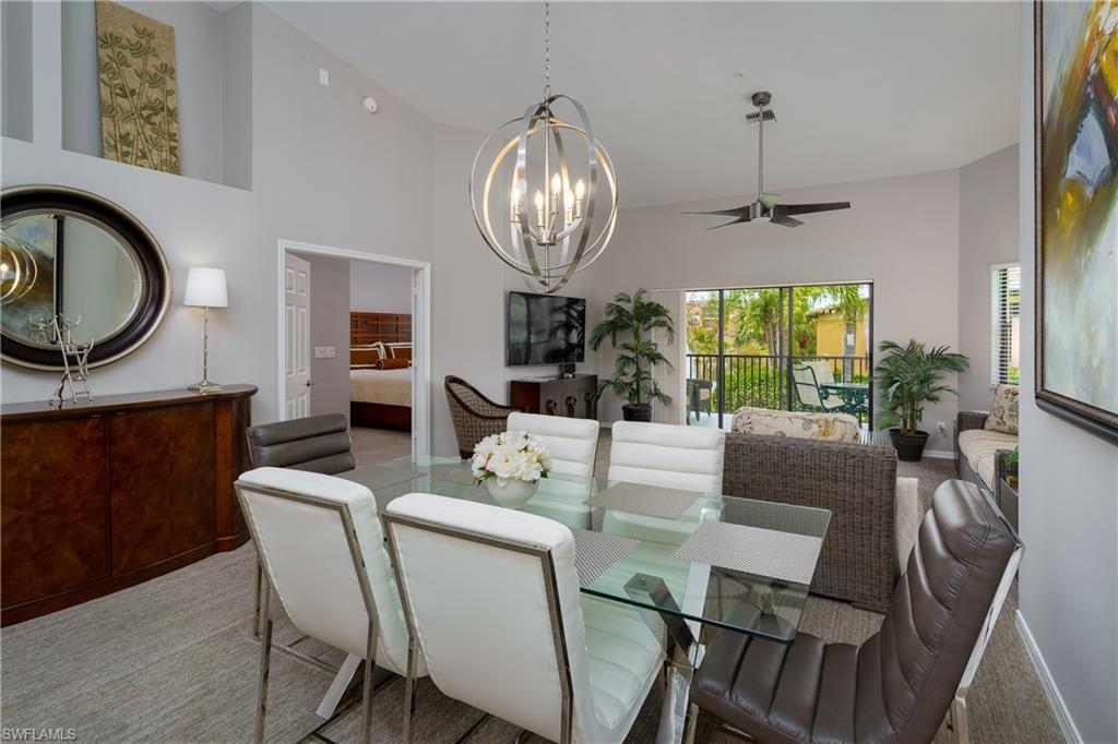 195 Vintage Circle, Unit E205 Naples, FL 34119 - Photo 7 of 34 a view of a dining room with furniture a chandelier and wooden floor