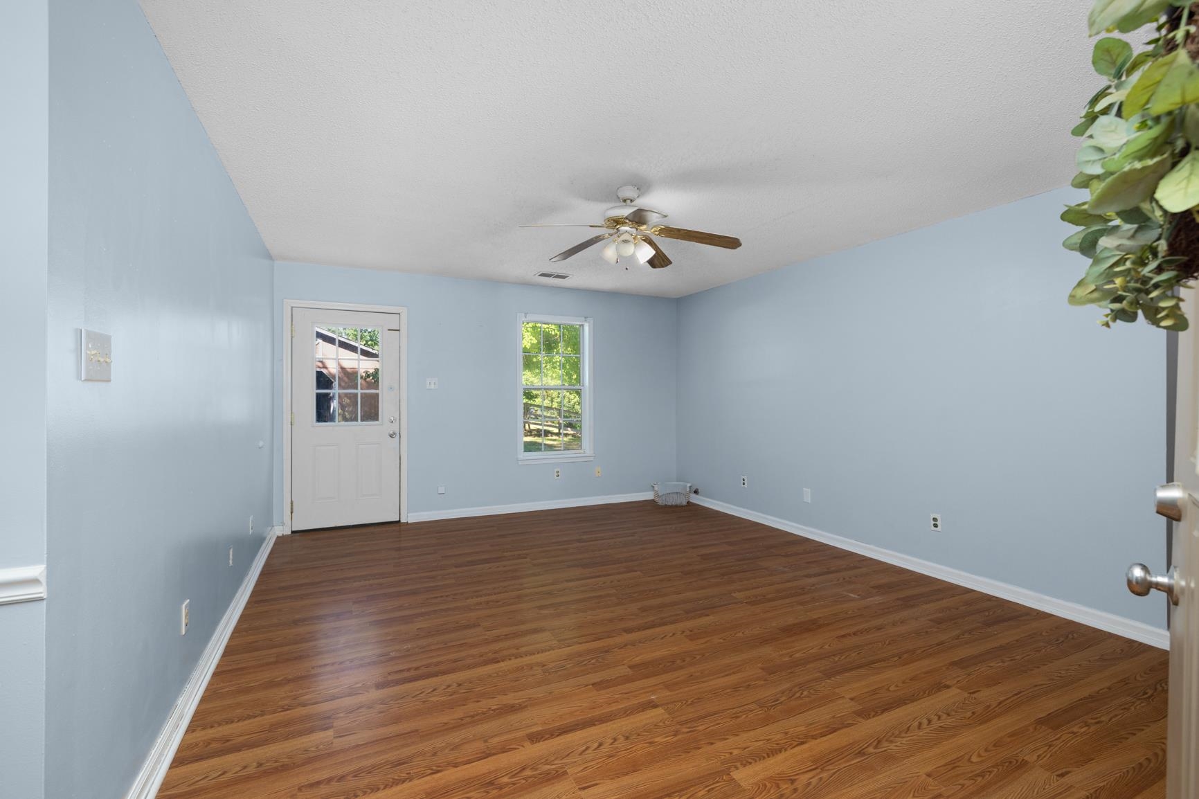 366 Adkins Road Burlison, TN 38015 - Photo 3 of 20 Spacious room featuring wood-finish flooring, light blue walls, and white trim