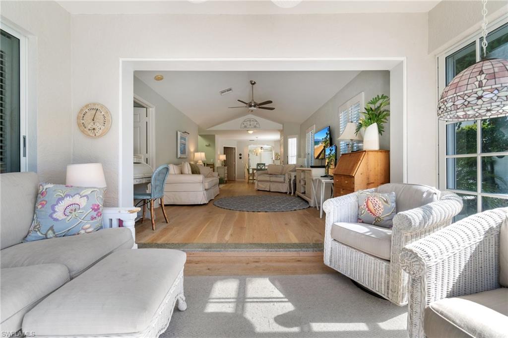 832 Rue Deville, Unit 5 Naples, FL 34108 - Photo 25 of 42 Living room featuring ceiling fan, light hardwood / wood-style flooring, and vaulted ceiling