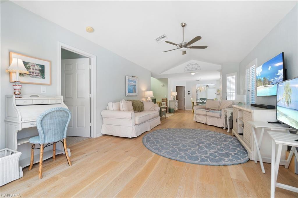 832 Rue Deville, Unit 5 Naples, FL 34108 - Photo 8 of 42 Living room with ceiling fan, light wood-type flooring, and vaulted ceiling