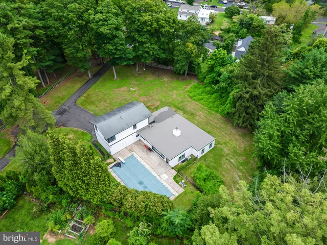 an aerial view of a house with swimming pool a yard and a yard