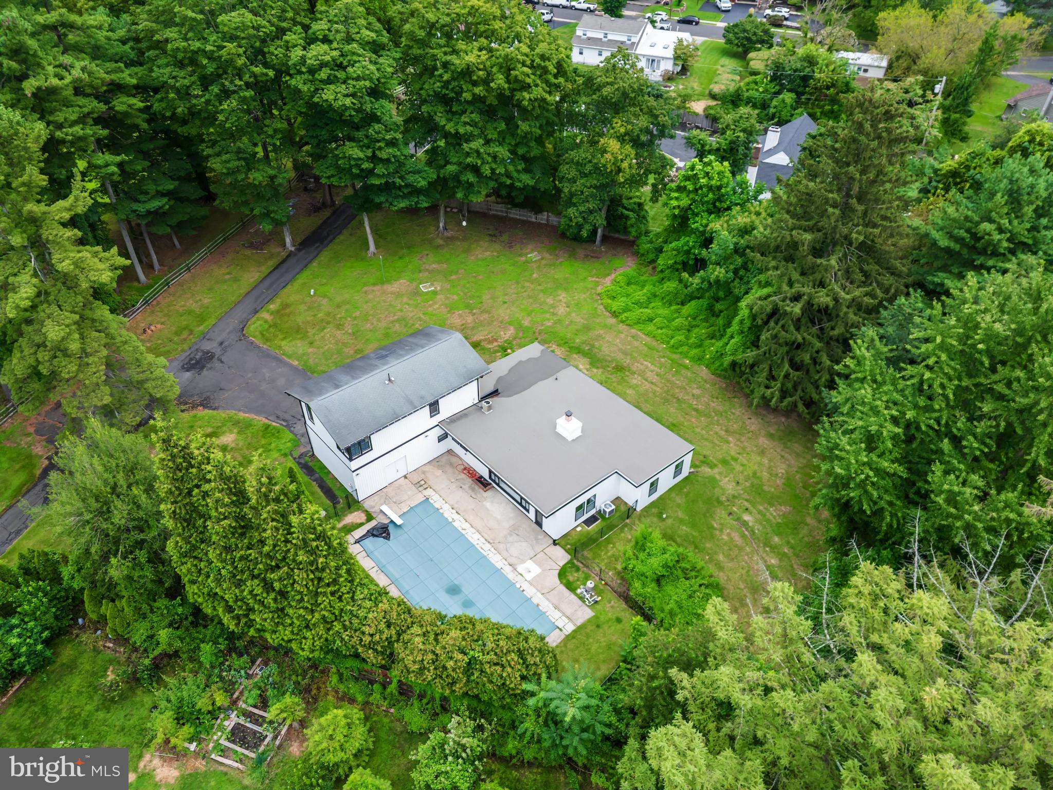 an aerial view of a house with swimming pool a yard and a yard