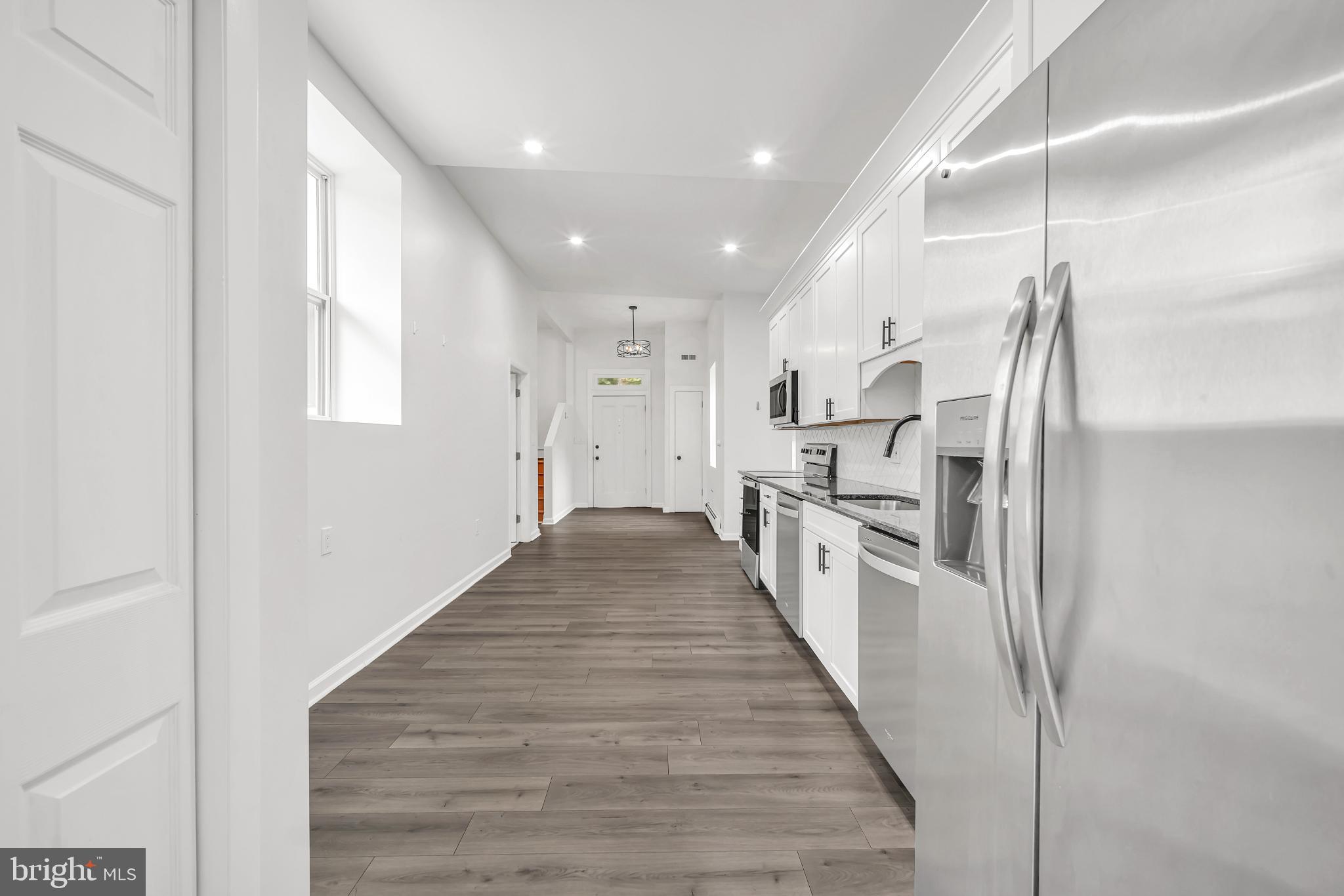 933 Fox Chase Road Jenkintown, PA 19046 - Photo 16 of 39 a kitchen with stainless steel appliances granite countertop a refrigerator a stove and a sink with wooden floor