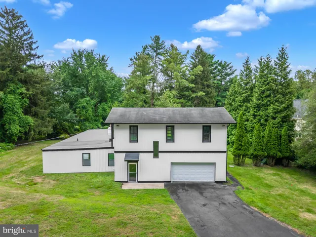a white house that has a tree in front of it