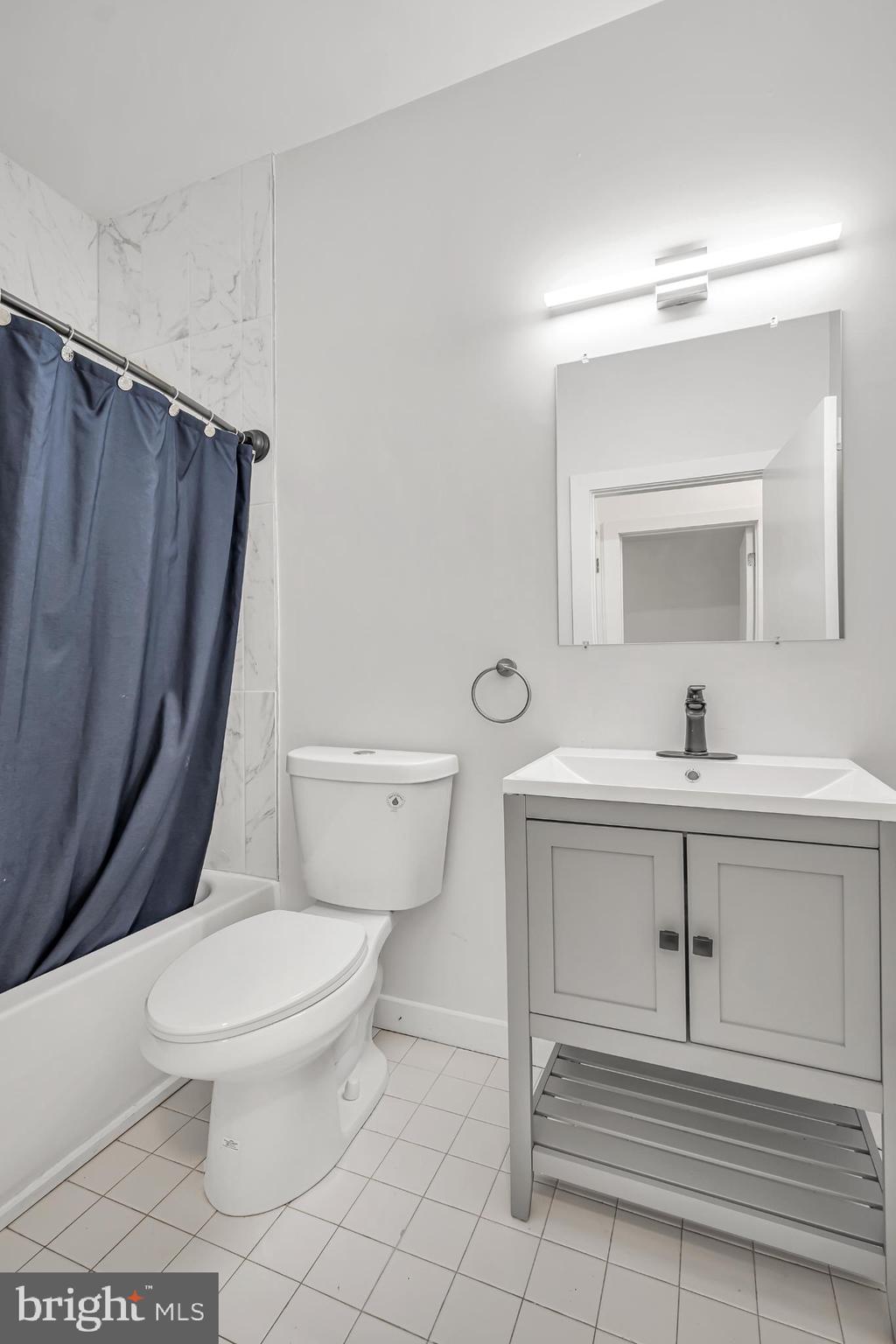 933 Fox Chase Road Jenkintown, PA 19046 - Photo 30 of 39 a bathroom with a sink a toilet a mirror and vanity