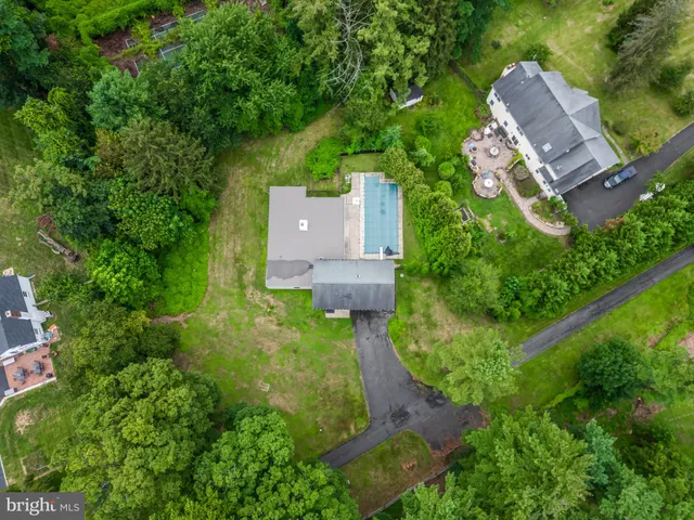 an aerial view of a house with a yard and a large tree