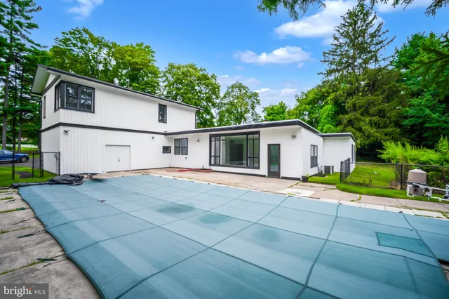 a view of a white house with a yard and large tree