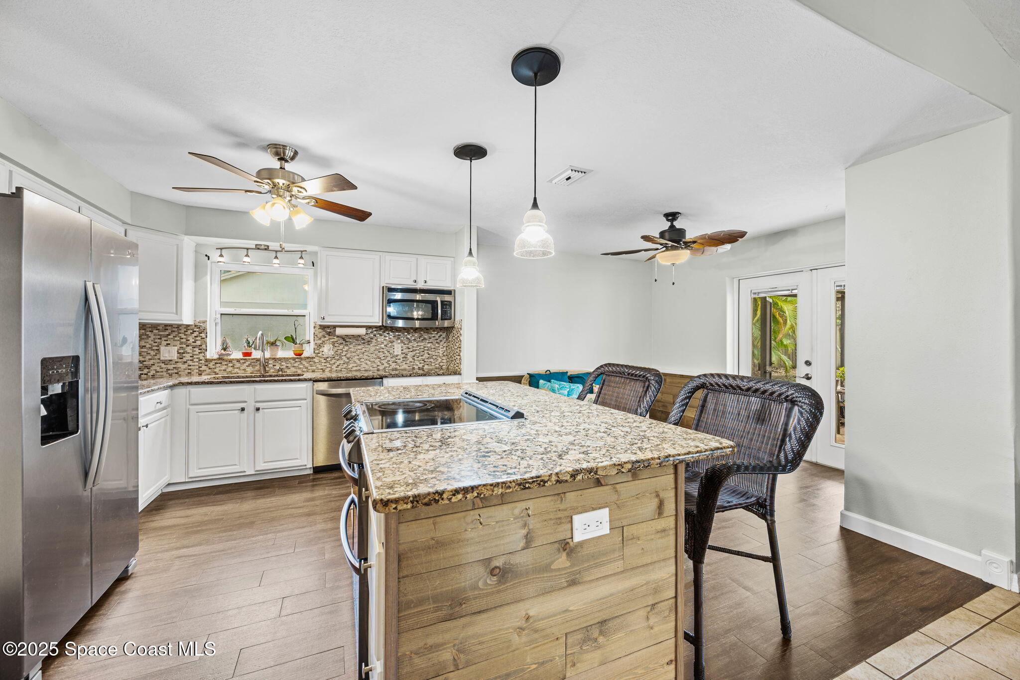 2568 Longwood Boulevard Melbourne, FL 32934 - Photo 26 of 42 a kitchen with a table a refrigerator and cabinets