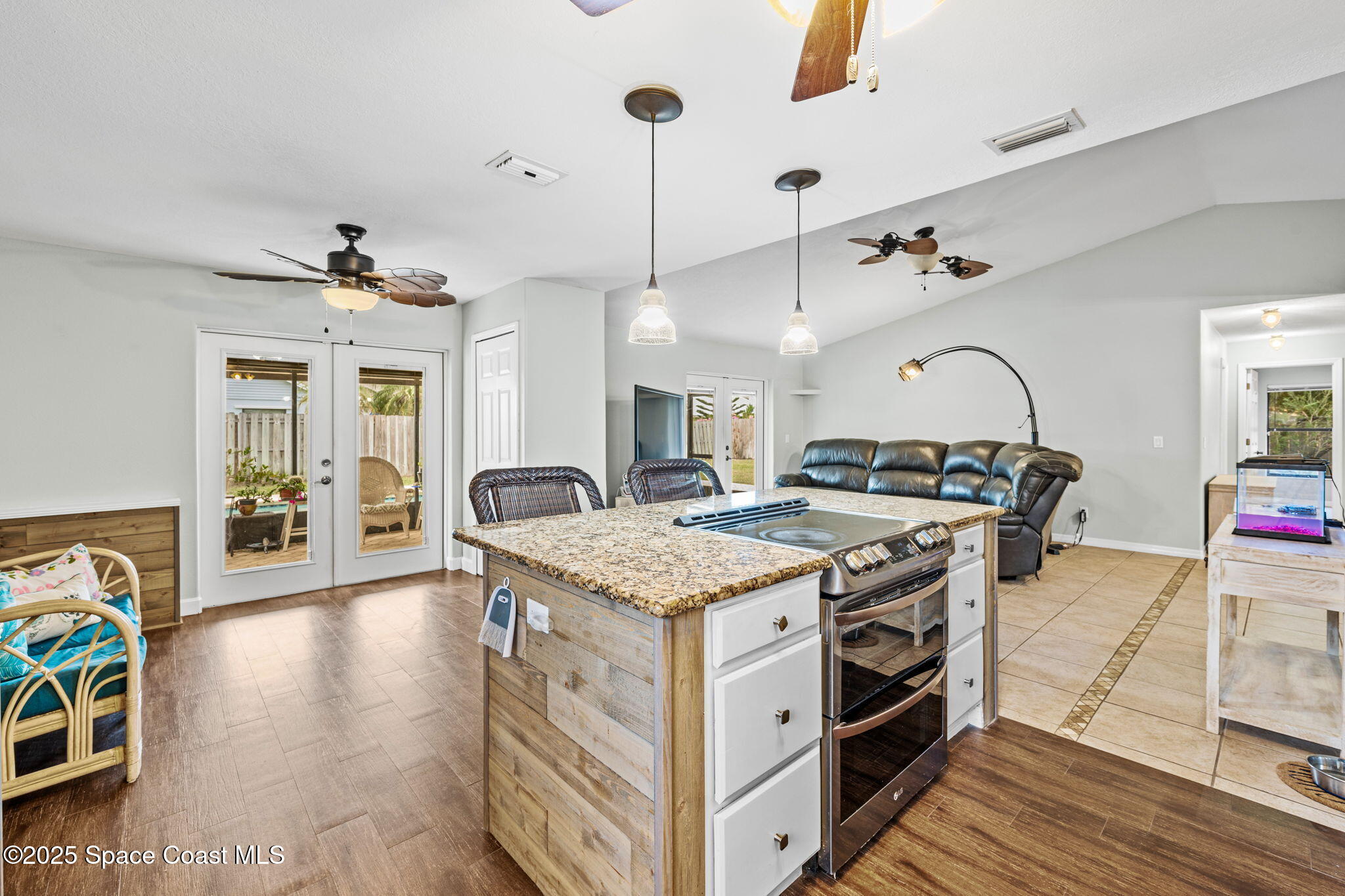 2568 Longwood Boulevard Melbourne, FL 32934 - Photo 29 of 42 a spacious kitchen with stainless steel appliances granite countertop a stove and a wooden floor