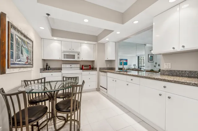 a kitchen with granite countertop white cabinets and stainless steel appliances
