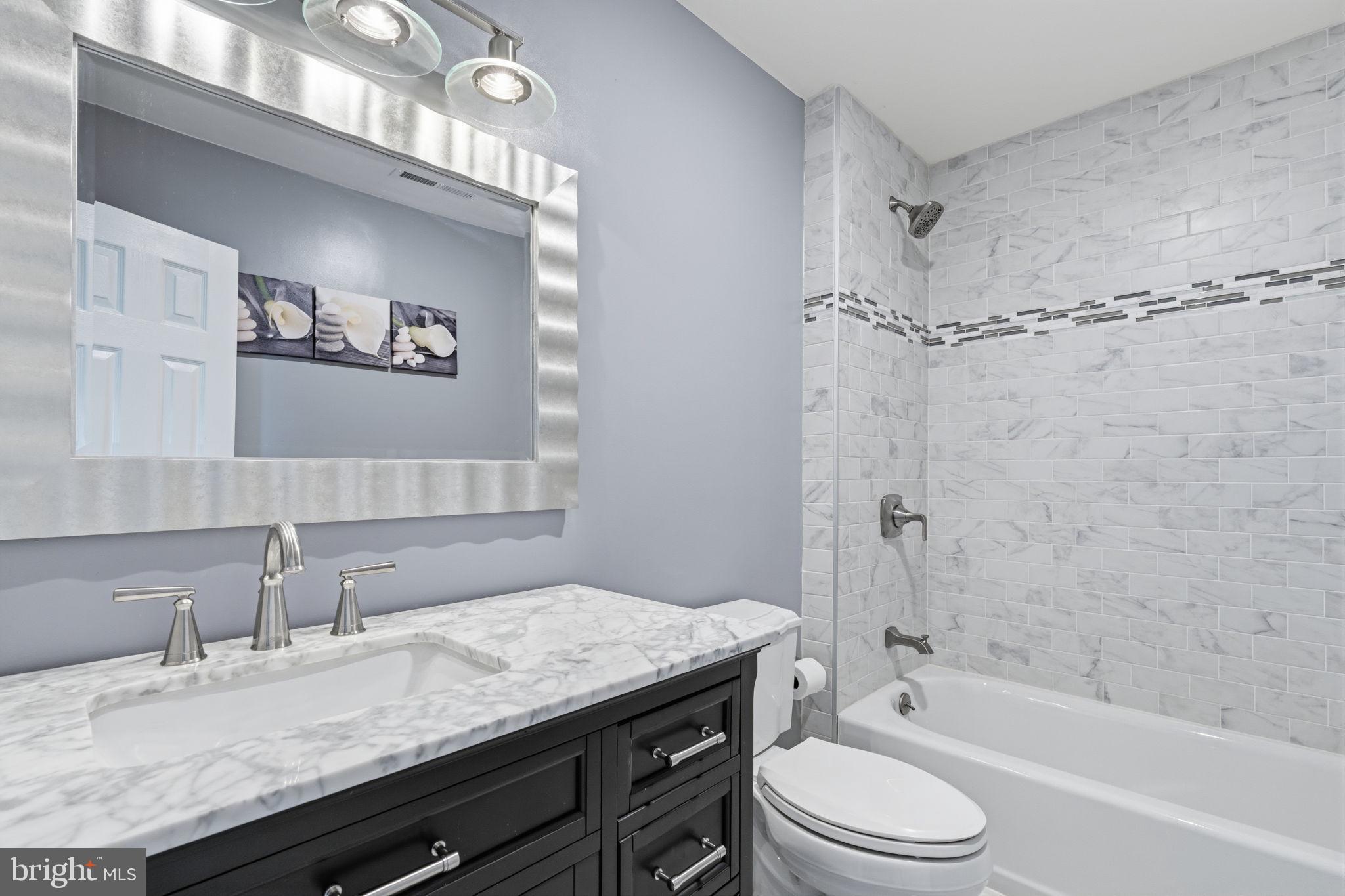 802 Eldridge Road Fairless Hills, PA 19030 - Photo 25 of 32 a bathroom with a granite countertop sink a toilet a mirror a bathtub and shower