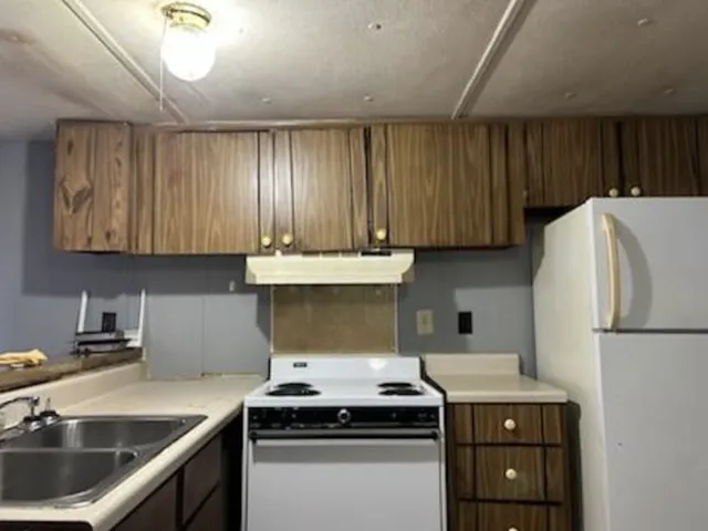 a kitchen with a sink a stove and refrigerator