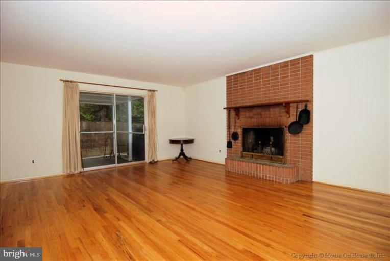 12809 Broadmore Road Silver Spring, MD 20904 - Photo 3 of 19 a view of an empty room with wooden floor fireplace and a window