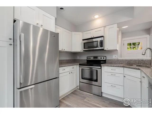 a kitchen with stainless steel appliances granite countertop a refrigerator stove a sink and a microwave